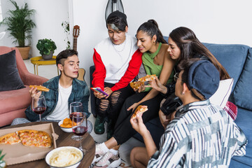 Group of latin LGBT friends eating pizza and drinks at home in Mexico, Hispanic homosexual and lgbtq community in Latin America