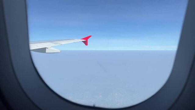 View of Airplane Wing From Window While Flying Above Sky