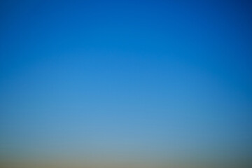 Sunset sky gradient from yellow to blue, copy space. Clear sunset sky with the bright light of the setting sun