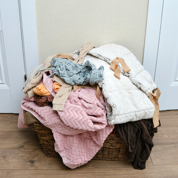 Filling the basket with adult and baby clothing. Sorting male and female clothes after washing