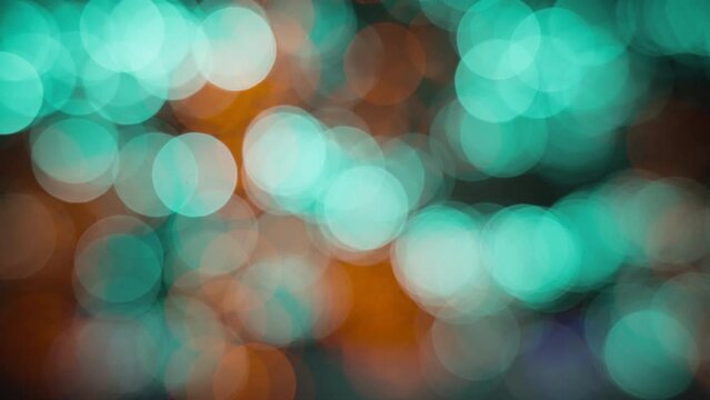 Teal and orange blurred bokeh round lights. Slow motion. Abstract background. 