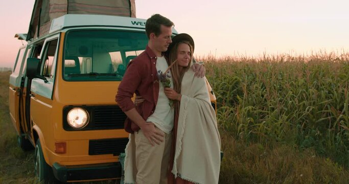 Slow Motion Romantic Young Loving Couple Hugging In Corn Field, Man embracing woman wrapping in blanket Faamily enjoying watching amazing sunset in the Countryside, Love Relationship Yellow camper van