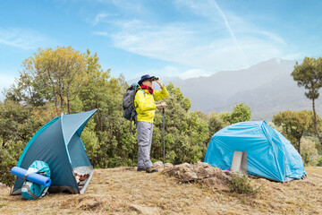 Portrait of an senior man, casually dressed, hiking in a mountain.