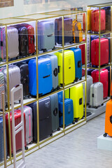 Different modern travel suitcases in the shop on discount, seasonal sale at the department store