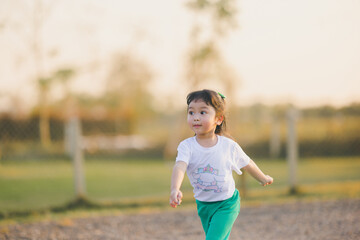 Freedom style of asia baby cute girl Jump play on a the outdoor playground with happy time on evening time