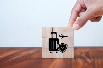 Travel safety and travel insurance concept ;wooden cube with grey background, copy space. Intended to cover medical expenses, trip cancellation, lost luggage and other losses incurred while traveling