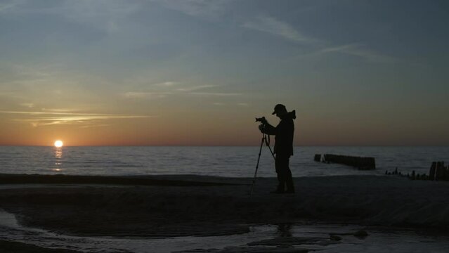 Photographer taking pictures on the beach at sunset. 