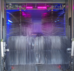 The rotating brushes of a carwash in action. The car being washed is hardly visible