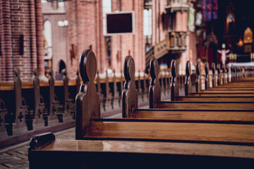 Fototapeta na wymiar Rows of church benches at the old european catholic church. 