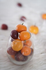 citrus and apple fruits in glass cup with ornament background