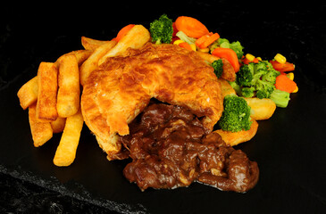 Steak and gravy puff pastry pie and chips meal with mixed vegetables