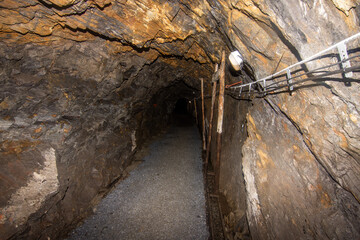 Old abandoned coal mine underground tunnel with wooden timbering
