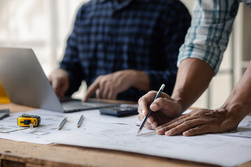 Group architects and engineers are in a meeting to discuss and inspect the house designs to meet the building and construction standards. Interior design and decoration ideas.