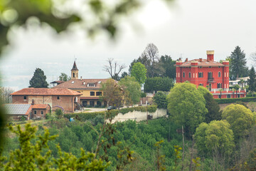 Panoramic view of the hills with green vegetation and a red castle or building from San Sebastiano da Po Castle, Torino, Piemonte region, Italy