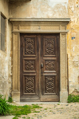 Old wooden door in an old street in San Sebastiano da Po Castle, Torino, Piemonte region, Italy, vertical