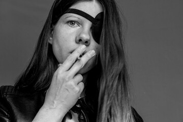 Girl smoking a cigarette with a black bandage on one eye black and white photo ,bad habit,smoking