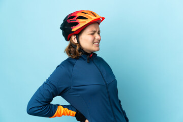 Young cyclist woman isolated on blue background suffering from backache for having made an effort