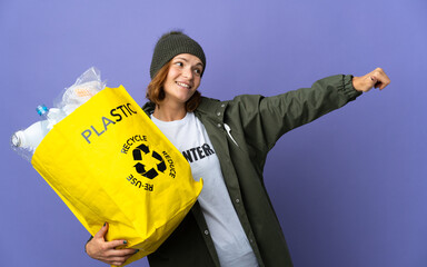 Young Georgian girl holding a bag full of plastic bottles to recycle giving a thumbs up gesture