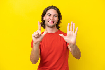 Caucasian handsome man isolated on yellow background counting seven with fingers