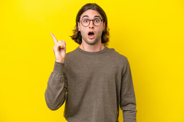 Caucasian handsome man isolated on yellow background intending to realizes the solution while lifting a finger up