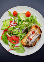 Sardines on sourdough toast with red birdseye chili and salad