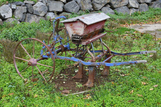 Vieille charrue rouill&eacute;e servant de semoirs servant de d&eacute;coration dans la cour d'une maison d'un petit village du puy de dome