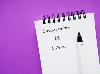 On pulple copy space background, pencil on note book with text written CONSERVATIVE VS LIBERAL,...