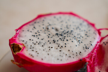 Pitaya (dragon fruit) cut in half with finer and black seeds showing