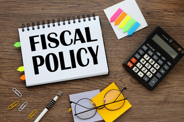 fiscal policy text on notepad pages with tacky bookmarks and stickers. calculator and glasses