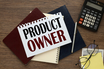 PRODUCT OWNER. text on the page of a notebook on three notebooks near the calculator