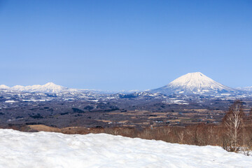 Fototapeta na wymiar 北海道洞爺湖町、丘の上から眺めた初春の羊蹄山と尻別岳【4月】