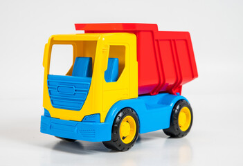 Plastic bright multi-colored toy construction vehicle on a white background.