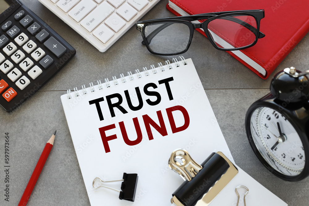 Poster trust fund. glasses on a red notepad near the notepad with text.