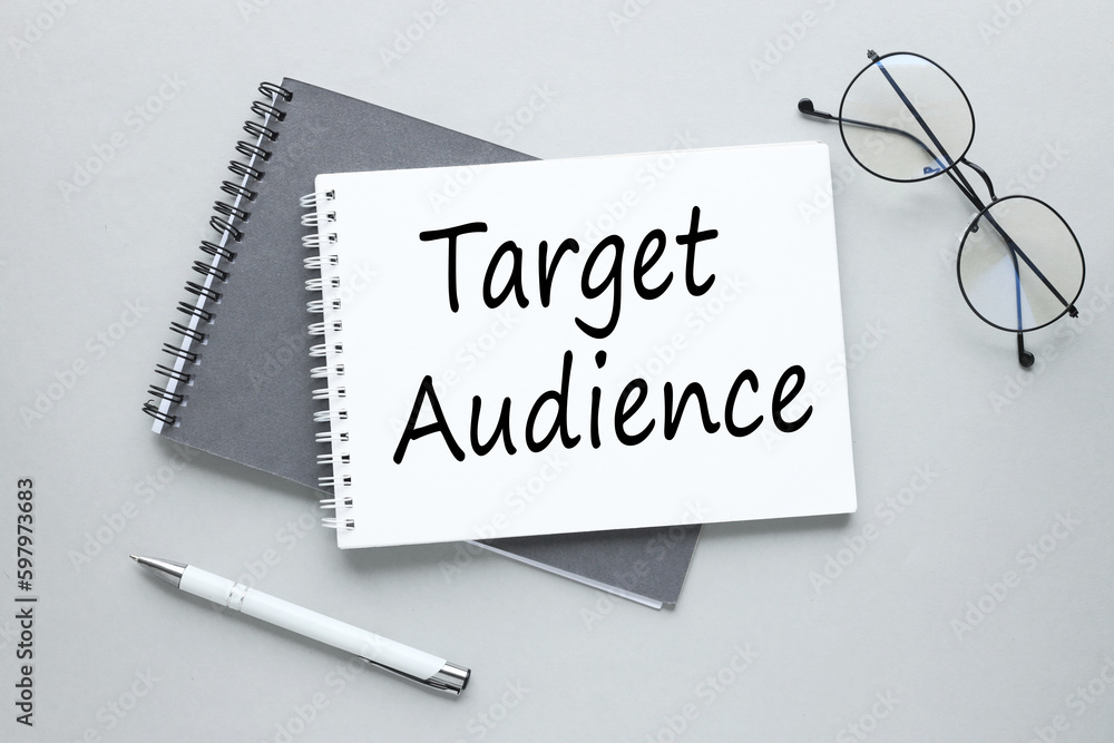 Poster target audience open notepad with text.glasses and pen gray background.