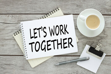 Let's work together open notepad on a wooden table. coffee on a brown wooden table at the workplace in the office.
