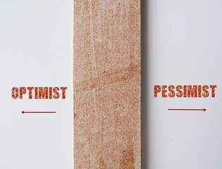 Wood divide white wall with text and direction point to OPTIMIST and PESSIMIT in opposite way -...