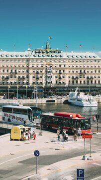 Stockholm, Sweden. Vertical Footage Video Traffic With Cars And Buses. Grand Hotel Located On Peninsula Blasieholmen. Touristic Pleasure Boats Floating Near Famous Grand Hotel In Sunny Generative AI