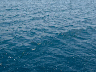Sea surface. Small waves on the surface of the blue sea. Blue water background.
