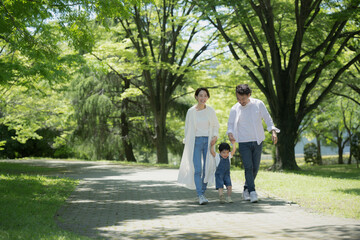 A friendly family taking a walk Image of a family holding hands in the fresh green