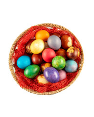 Top view of multicolored Easter eggs in a basket at white background. Pastel colored Easter eggs.