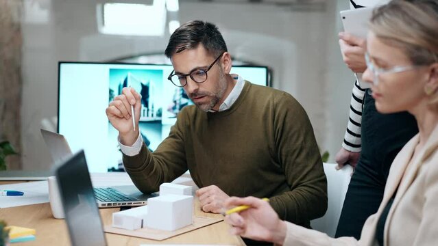 Video of smart group of architects working with laptops and blueprints while talking of their new design business in the office.