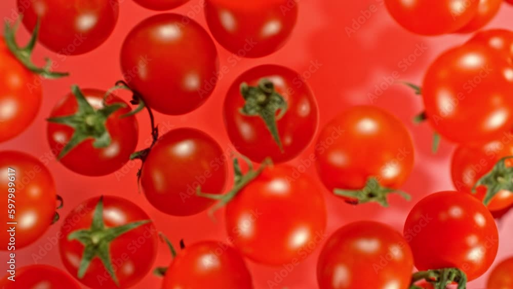 Poster super slow motion of cherry tomatoes flying on red background. filmed on high speed cinema camera, 1