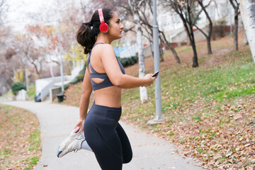 young woman in sports suit warming up before jogging