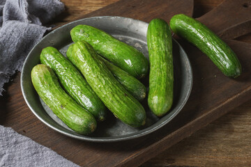 Crunchy mini cucumbers on a rustic plate