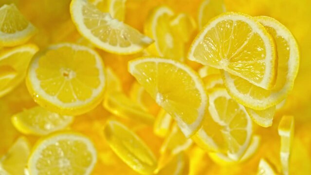 Super slow motion of flying lemon slices on black background. Filmed on high speed cinema camera, 1000 fps. Camera placed on high speed cine bot, tracking the object. Speed ramp effect.