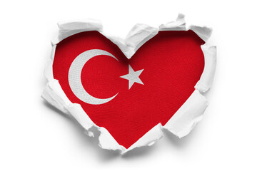 Heart shaped hole torn through paper, showing satin texture of flag of Turkey, cut out