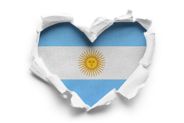 Heart shaped hole torn through paper, showing satin texture of flag of Argentina, cut out