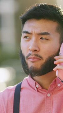 Stylish asian man arguing on the phone outdoors