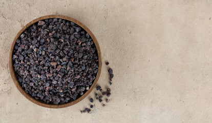 Himalayan crystal black salt in a wooden bowl on a beige background. Spices background. Flatlay. Copy space. 