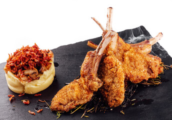 Roasted pork ribs, garnished with onion chips and mashed potatoes